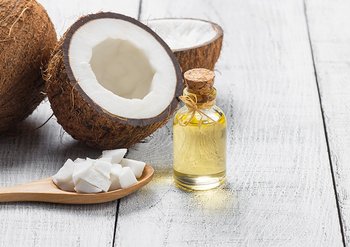 Kokosnuss halbiert & Flasche mit Kokosöl