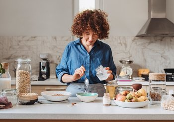 Ein junge Frau mischt die Zutaten in einer Schale