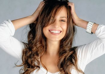 Frau hält sich glücklich ihre dicke Haarpracht