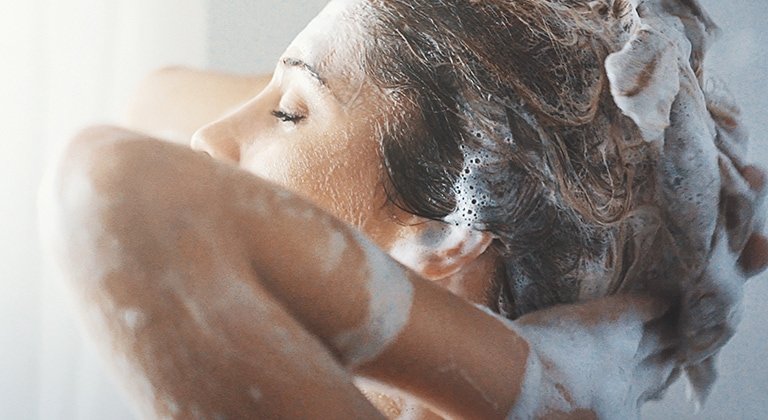 Frau wäscht ihre Haare