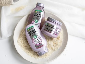 Garnier Wahre Schätze Reiswasser Haarpflege-Serie in einer Schale mit Reis