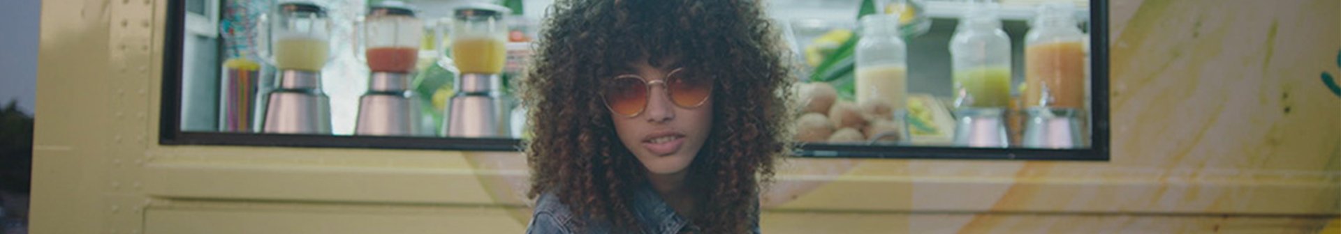 Frau mit lockigen Haaren vor einem Schaufenster