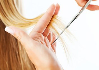 Frau schneidet Haarspitzen