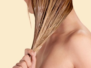 Blonde Frau, die ihre nassen Haare auswringt