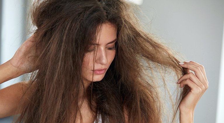 Frau mit langen, sehr widerspenstigen Haaren