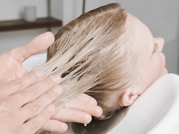 Blonde Frau bekommt die Haare gewaschen