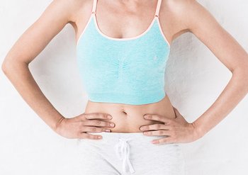 Frau berührt die Haut ihres Bauches