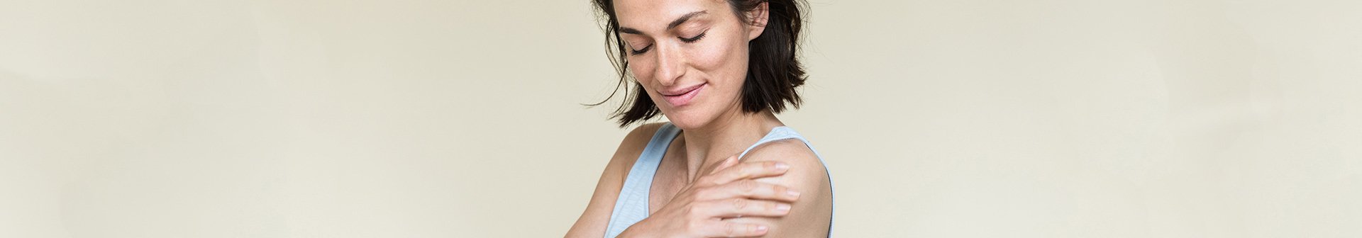 Frau trägt Bodylotion auf