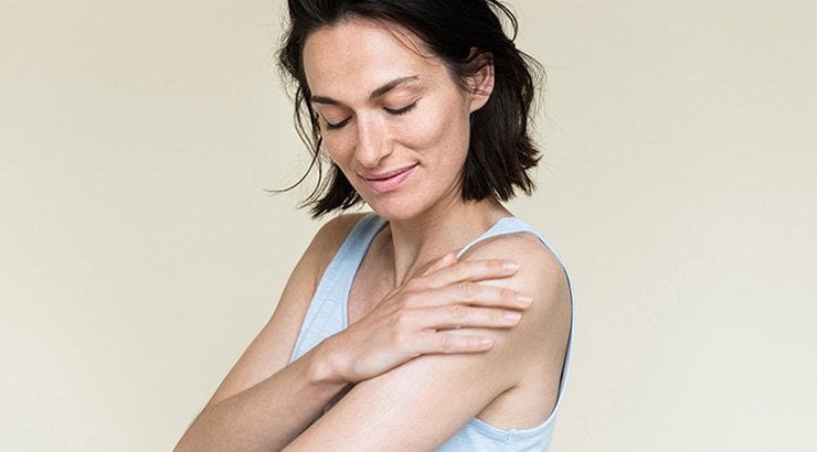 Frau trägt Bodylotion auf