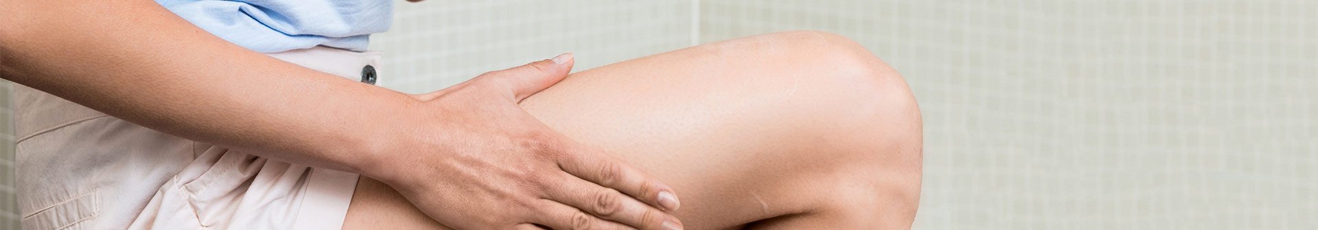 Frau trägt Cellulite-Creme auf