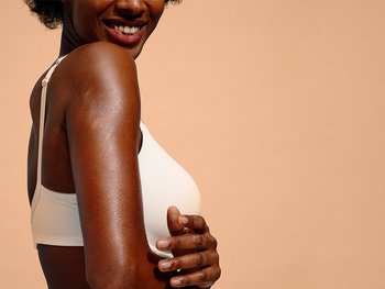 Eine Frau streicht mit der Hand über ihren Arm