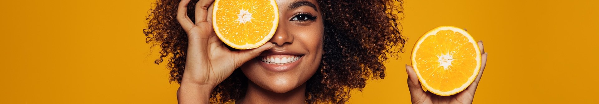Gesicht einer Frau mit Orangen in der Hand