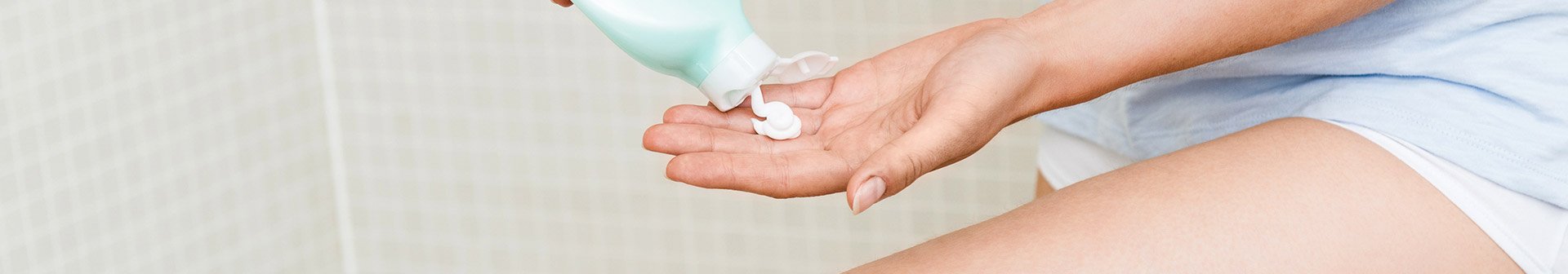 Frau trägt Creme auf ihre Hand auf