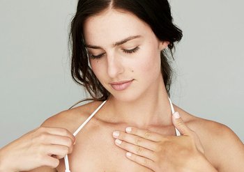 Frau trägt Creme auf ihrer Haut auf