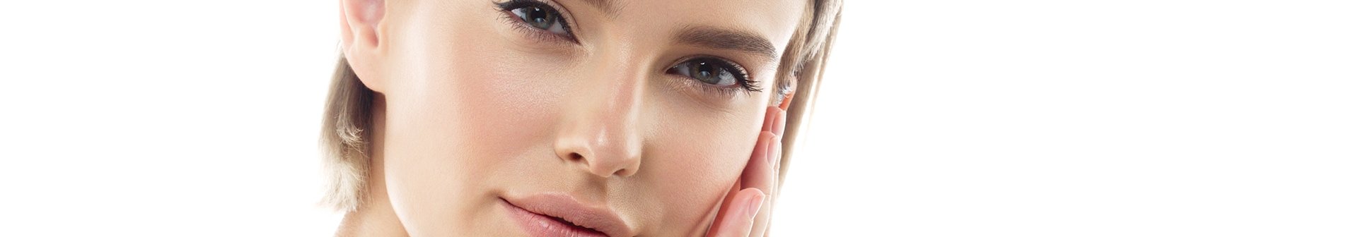 Junge Frau streicht sich über ihre linke Wange