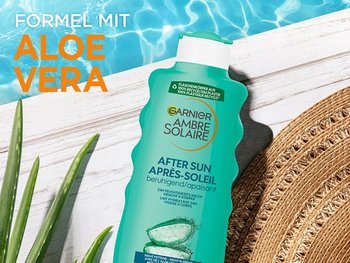 Ambre Solaire After Sun 24h Feuchtigkeits-Milch am Pool neben einer Aloe Vera Pflanze und einem Sonnenhut