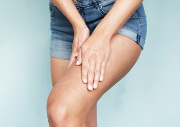 Frau berührt ihr Bein