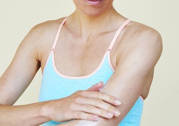 Frau berührt ihren Arm