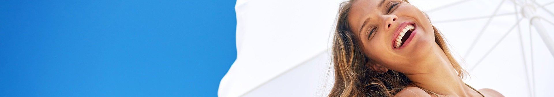 Lachende Frau unter Sonnenschutz