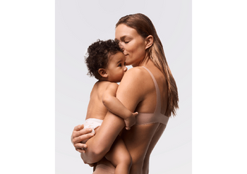 Mutter hält Baby im Arm, Fokus auf Hautschutz und Sonnencreme in der Schwangerschaft