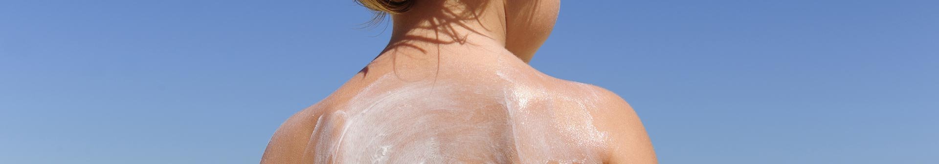 Kind mit Sonnencreme auf dem Rücken