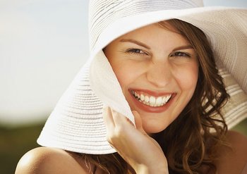 Lachende Frau mit weißem Sonnenhut