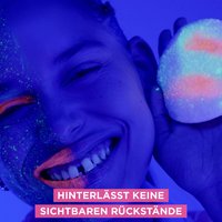 Lächelnde Frau mit einer geschminkten und einer ungeschminkten Gesichtshälfte