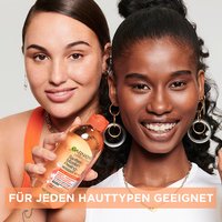 Zwei lächelnde Frauen halten Garnier SkinActive Sanftes Mizellen Reinigungswasser mit Peeling-Effekt hoch