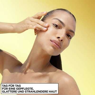 Eine junge Frau, die die Garnier Vitamin C Glow Boost Tagespflege auf ihrem Gesicht anwendet.