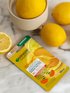 SkinActive Glow Booster Augen-Tuchmaske - Produkt liegend mit einigen Zitronen