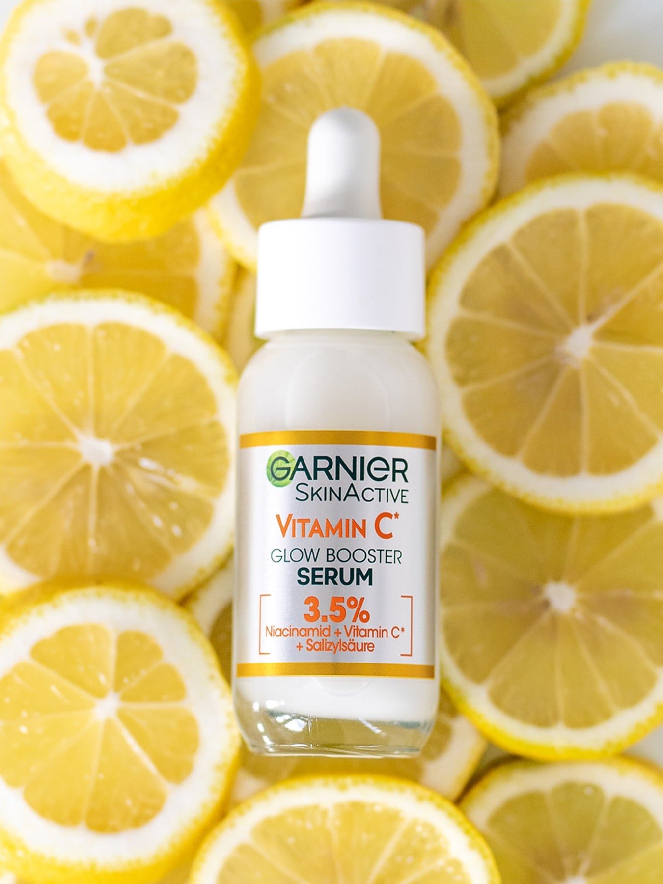 Vitamin C Glow Boster Serum liegt auf Zitronenscheiben
