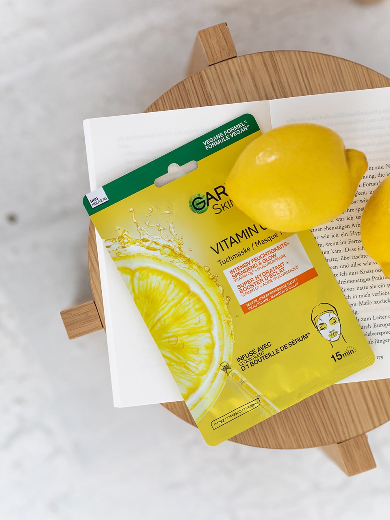 Vitamin C Routine Tuchmaske zusammen mit Zitronen auf einem Hocker