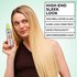 Ein junges, blondes, weibliches Model hält das Garnier Fructis Diamond Sleek Shine-Coat Glättigungsspray neben ihr Gesicht und schaut auf die Resultate - bis zu 100H brillianter Glanz, und strahles, extrem sleekes, geschmeidiges Haar.