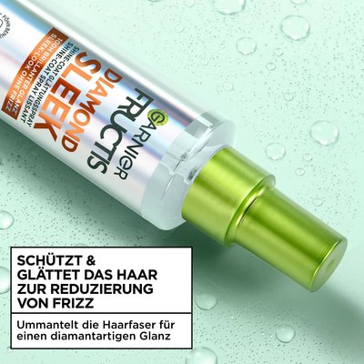 Das Garnier Fructis Diamond Sleek Shine-Coat Glättigungsspray liegt vor einem Hintergrund mit sanften flüssigen Tropfen.