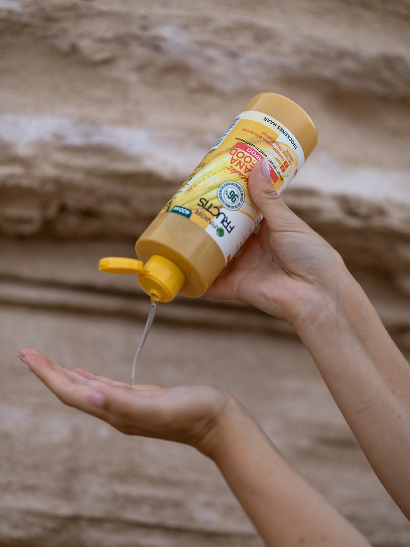 Eine Person trägt sich pflegendes Shampoo mit Banane auf ihre Hände auf