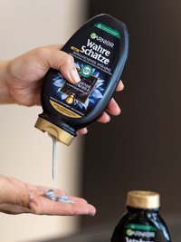 Wahre Schätze Aktivkohle Ausgleichende Spülung wird auf eine Hand aufgetragen