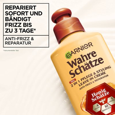 Die Wahre Schätze Leave-In-Creme Honig Schätzeim Vordergrund vor cremiger, sanfter Textur, oben links ein Schriftzug mit Produktbeschreibung