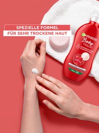 Eine Person streicht ihren linken Arm mit Garnier Body Repair ein, plus Produktabbildung