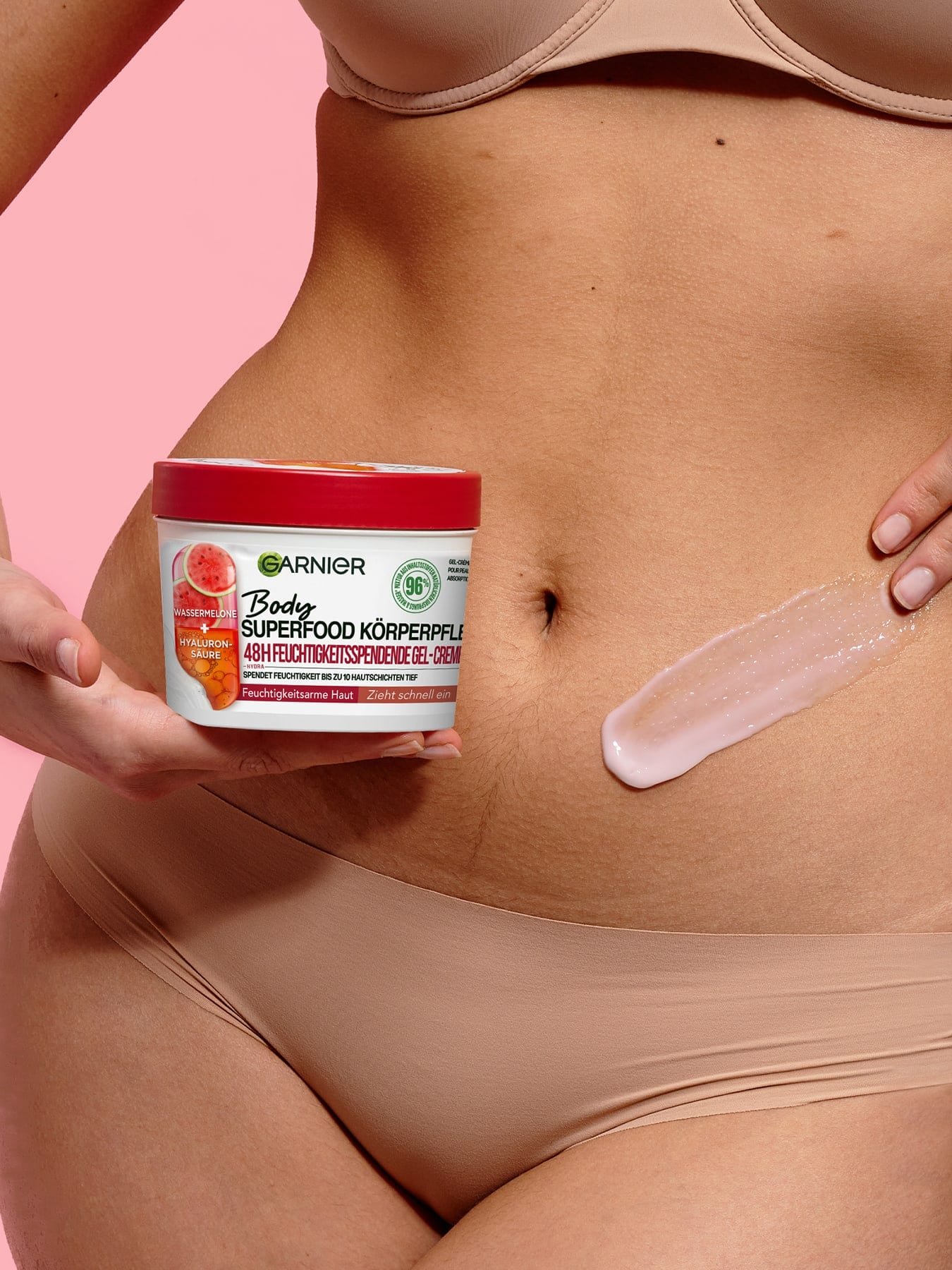 Eine Frau trägt Body Superfood 48h feuchtigkeitsspendende Gel-Creme auf ihren Bauch auf