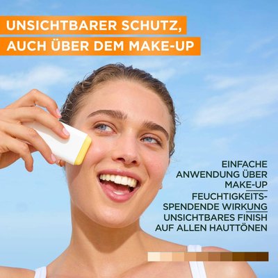 Model die glücklich lächelnd vor einem blauen Himmel steht und den Garnier Sunstick auf ihrer Backe anwendet.