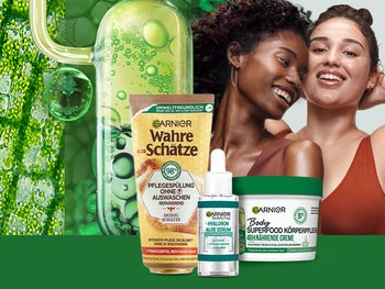 Zwei junge Frauen und einige Garnier Produkte vor grünem Hintergund