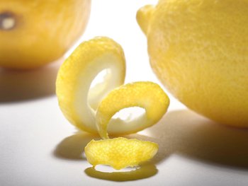 Ein Ausschnitt zeigt zwei Zitronen; zwischen ihnen liegt eine Zitronenzeste.