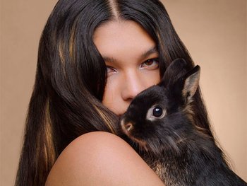 Eine Frau trägt ein Kaninchen in ihren Armen