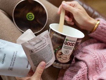 Frau hat Garnier GOOD auf dem Schoß und packt die Bestandteile aus