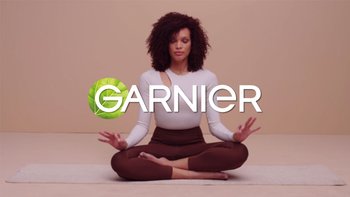 Frau sitzt im Schneidersitz und meditiert