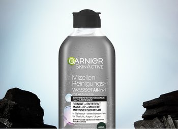 Mizellen Reinigungswasser Aktivkohle Produktbild mit Kohlestücken im Hintergrund