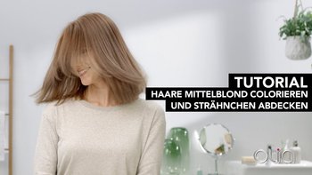 Mittelblonde Frau mit beigem Oberteil schüttelt ihr Haar