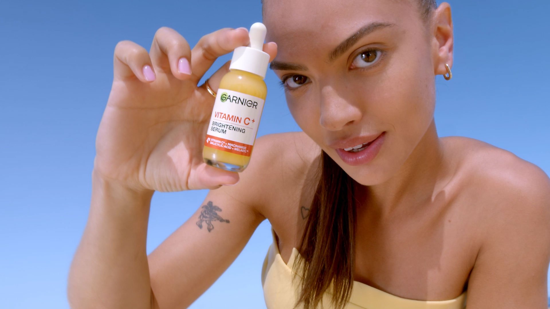Frau hält Vitamin C Glow Serum in ihrer Hand
