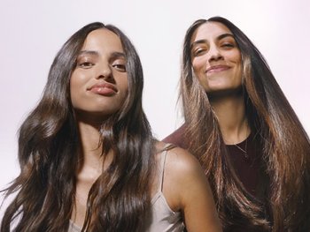 Zwei lächelnde brünette Frauen